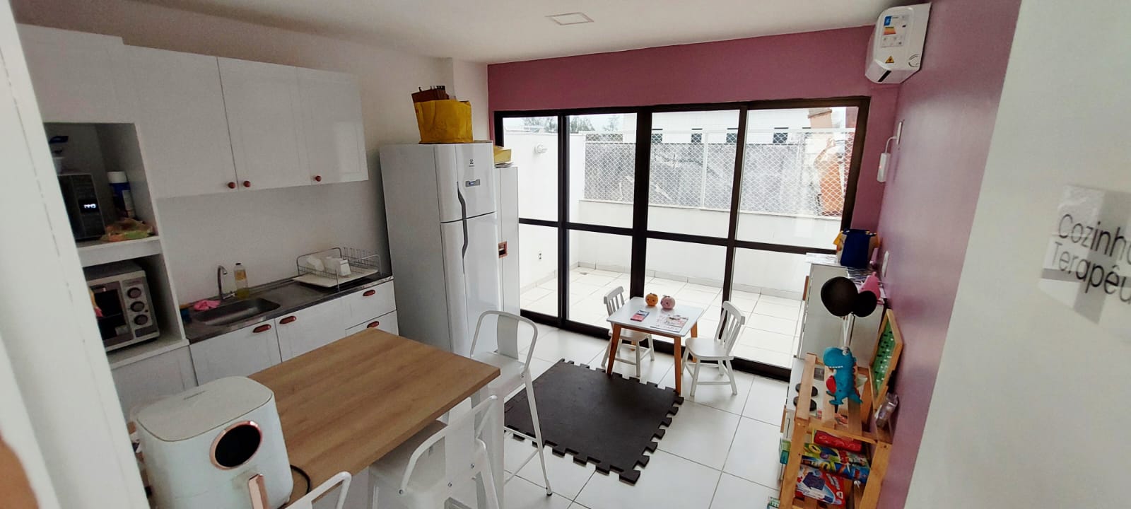 Cozinha terapêutica do Espaço CoReS com bancada, mesinha infantil e área ampla iluminada.